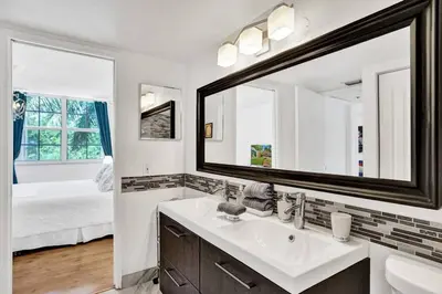 a bathroom with a sink and a mirror and a bed at Renovated cozy The yacht club at aventura Parking included in Miami