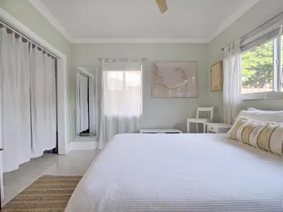 a bedroom with a large white bed and windows at Surf House - Paddleboards - Canoes -1 mile to Wilton Manors in Fort Lauderdale