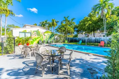 a patio with tables and chairs next to a swimming pool at Renovated Apts with Kitchen, Fast WiFi, Smart TV, Roku & Pool Onsite 4 mi to Surfside Beach in North Miami