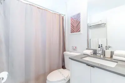 a white bathroom with a toilet and a shower at Renovated Apts with Kitchen, Fast WiFi, Smart TV, Roku & Pool Onsite 4 mi to Surfside Beach in North Miami