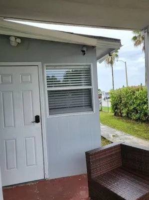 a building with a door and a window and a bench at 13101 Main Apartment Miami in Miami