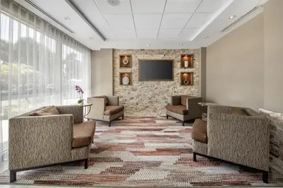a waiting room with chairs and a flat screen tv at Best Western Plus North Miami-Bal Harbour in North Miami