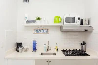 a kitchen counter with a sink and a microwave at West Deco in Miami Beach