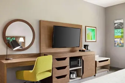 a room with a tv and a yellow chair at Hampton Inn & Suites Miami, Kendall, Executive Airport in Kendall