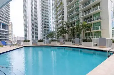 a large blue swimming pool in front of some buildings at Comfortable 2 BR at Brickell , Free Parking in Miami