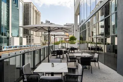 a restaurant with tables and chairs and a balcony with buildings at Element Miami Brickell in Miami