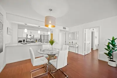 a dining room and kitchen with a glass table and white chairs at Amazing Condo with FREE PARKING in Brickell Miami in Miami