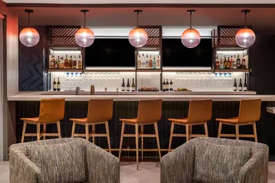 a bar with chairs and lights in a room at Atwell Suites Miami Brickell by IHG in Miami