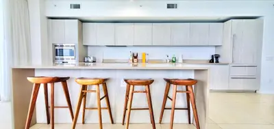 a kitchen with wooden stools at a counter at Dramatic Ocean View at Hyde Resort And Residences in Hollywood