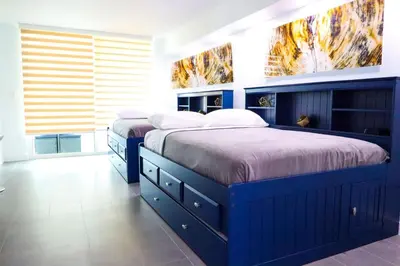 two beds in a bedroom with blue cabinets at Luxury Accommodations Brickell in Miami