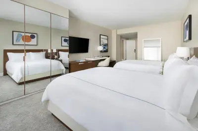 a hotel room with two beds and a mirror at The Altair Bay Harbor Hotel in Miami Beach