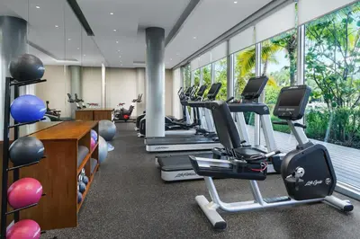 a gym with a row of treadms and elliptical machines at The Altair Bay Harbor Hotel in Miami Beach
