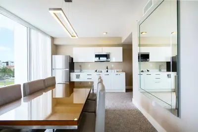 a kitchen with white cabinets and a large window at The Altair Bay Harbor Hotel in Miami Beach