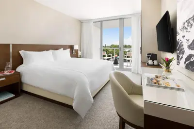 a hotel room with a large bed and a balcony at The Altair Bay Harbor Hotel in Miami Beach