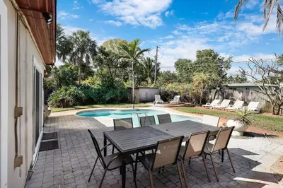 a patio with a table and chairs next to a pool at Home wpool by PMI unit 401 in Fort Lauderdale