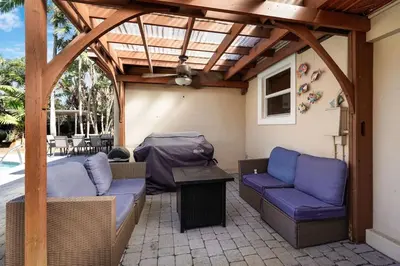 a patio with two couches and a wooden pergola at Home wpool by PMI unit 401 in Fort Lauderdale