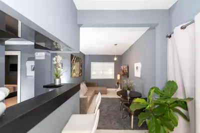 a living room with blue walls and a dining room at Sunny Days Apartments in Miami Beach