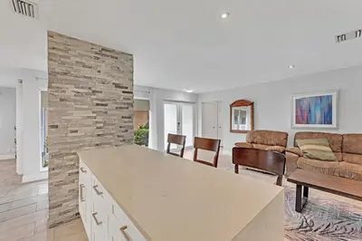 a kitchen and living room with a stone wall at SuperVilla - 3BR/2BA - Pool - Walk to beach in Hollywood