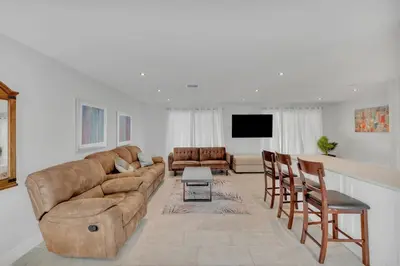 a living room with a couch and a table at SuperVilla - 3BR/2BA - Pool - Walk to beach in Hollywood
