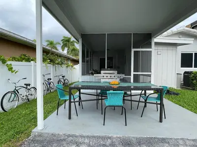 a patio with a table and chairs and a kitchen at SuperVilla - 3BR/2BA - Pool - Walk to beach in Hollywood
