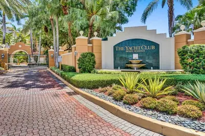 a walkway in front of a building with palm trees at Yacht Club Newly renovated parking included in Aventura