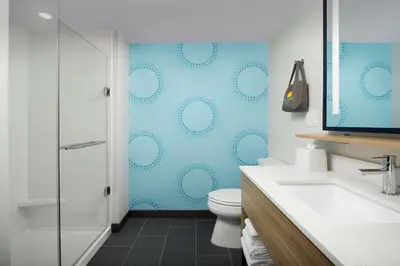 a bathroom with a toilet and a blue wall at Tru By Hilton Miami Airport South Blue Lagoon, Fl in Miami