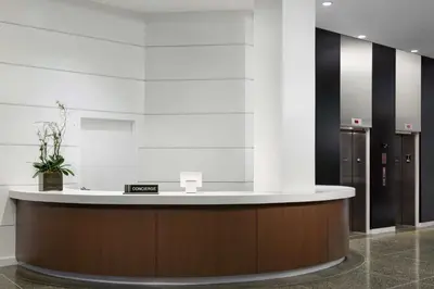 a lobby with a reception counter with a potted plant at Hilton Cabana Miami Beach Resort in Miami Beach