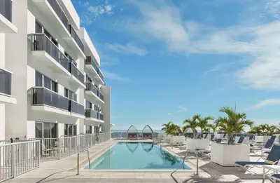 a view of a hotel with a swimming pool and chairs at Hilton Cabana Miami Beach Resort in Miami Beach