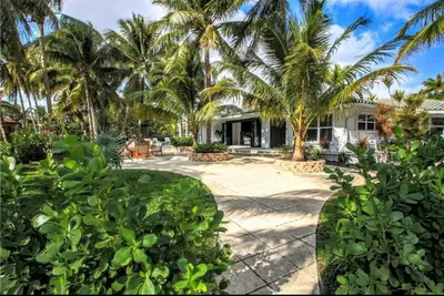 an exterior view of a house with palm trees at SWAYING PALM BEACH HOUSE Walk to Beach , Marina, Port, las Olas in Fort Lauderdale
