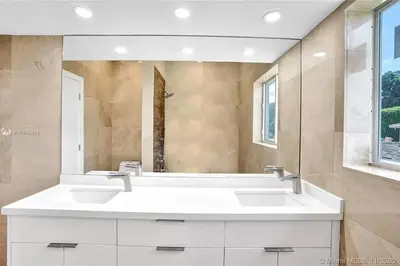 a bathroom with two sinks and a large mirror at Pool Villa in Miami