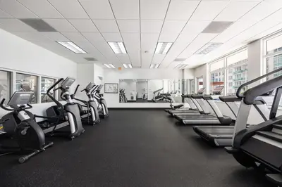 a gym with rows of treadmills and elliptical machines at Two Bedroom Oceanview Apartment in Brickell in Miami