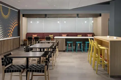 a dining room with tables and chairs and a bar at Tru By Hilton Miami West Brickell in Miami