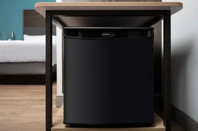 a black trash can under a table next to a bed at Tru By Hilton Miami West Brickell in Miami