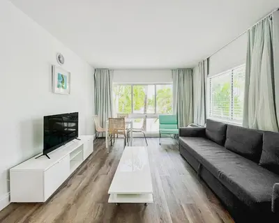 a living room with a couch and a tv at Tranquilo in Fort Lauderdale