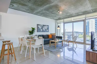 a living room with a blue couch and a table and chairs at Relax Family Midtown - free parking & Great pool in Miami