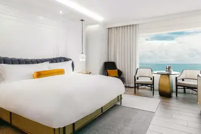 a bedroom with a bed and a table and chairs at The Ritz-Carlton, South Beach in Miami Beach
