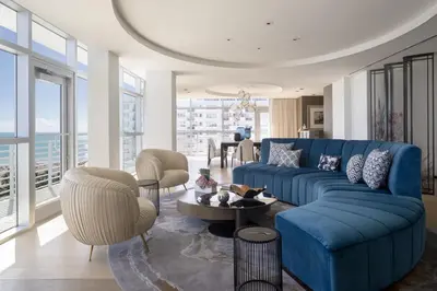 a living room with a blue couch and chairs at The Ritz-Carlton, South Beach in Miami Beach