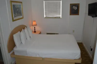 a bed with white sheets and pillows in a room at Island House South Beach in Miami Beach