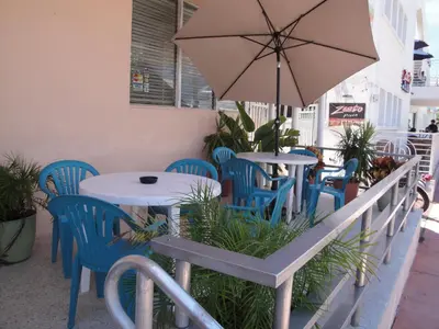 a table and chairs with an umbrella on a patio at Island House South Beach in Miami Beach