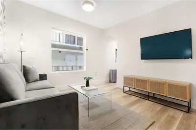 a living room with a couch and a flat screen tv at Roami at The Carmela in Miami Beach
