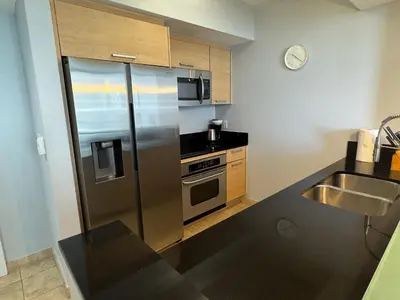 a kitchen with a stainless steel refrigerator and a sink at MVR Apartments at Marenas in Miami Beach