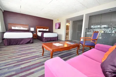 a hotel room with two beds and a couch at Sea Club Ocean Resort in Fort Lauderdale