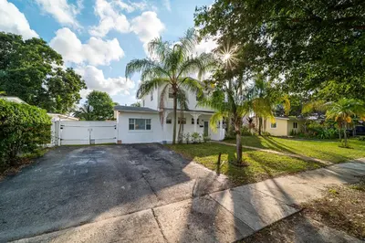 a house with a palm tree in front of a driveway at Pool Home in Hollywood