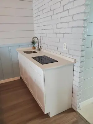 a kitchen with a sink and a white brick wall at Hollywood Gardens Inn & Suites in Hollywood