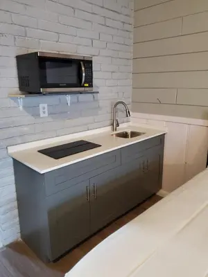 a kitchen with a sink and a microwave at Hollywood Gardens Inn & Suites in Hollywood