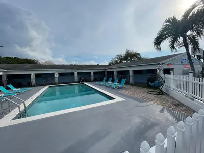 a swimming pool with lounge chairs and a building at Hollywood Gardens Inn & Suites in Hollywood