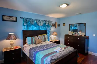 a bedroom with blue walls and a bed with two lamps at Fabulous Hollywood Living Space in Hollywood
