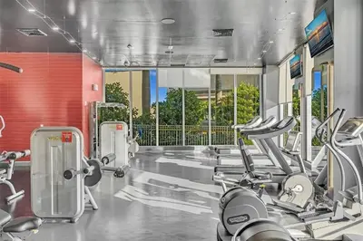 a gym with several treadmills and elliptical machines at Beachwalk Resort Hallandale Ocean and Canal View Apartments 5 Min from the Beach in Hallandale Beach