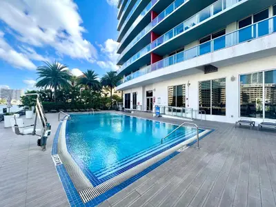 a large swimming pool in front of a building at Beachwalk Resort Hallandale Ocean and Canal View Apartments 5 Min from the Beach in Hallandale Beach