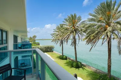 a balcony with palm trees and the ocean at Beach Haus Bal Harbour in Miami Beach